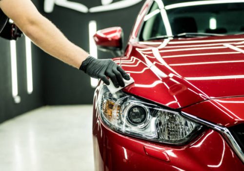 Car service worker applying nano coating on a car detail